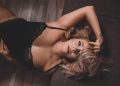 Woman in black lingerie lying down during a boudoir confidence journey story.