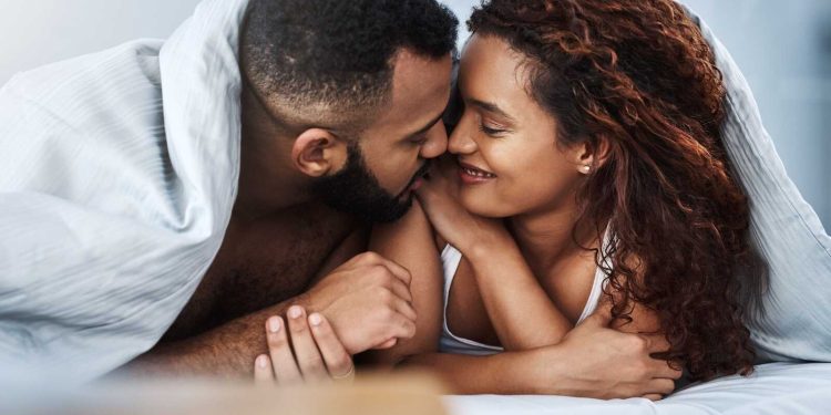 Married couple cuddling in bed representing Christian Sex Tips for loving, faith-centered intimacy.