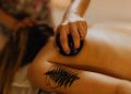 Therapist using a smooth stone during a restorative touch massage on a woman’s back.