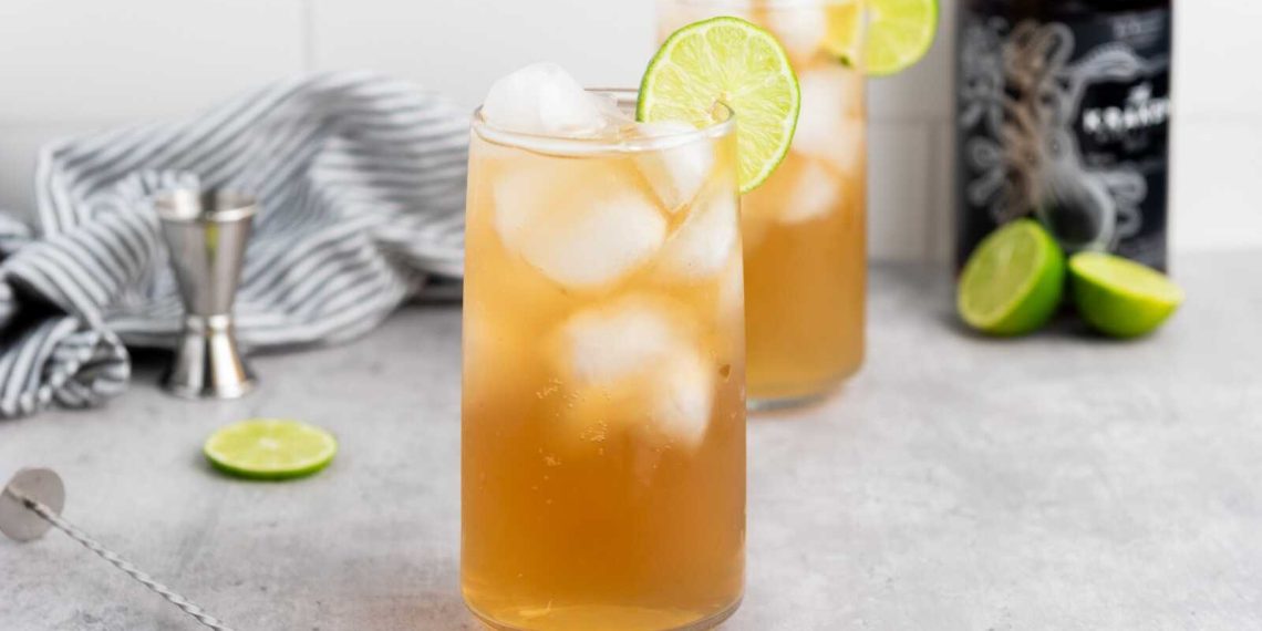 Dark and Stormy cocktail with dark rum, ginger beer, ice, and lime garnish in a tall glass.