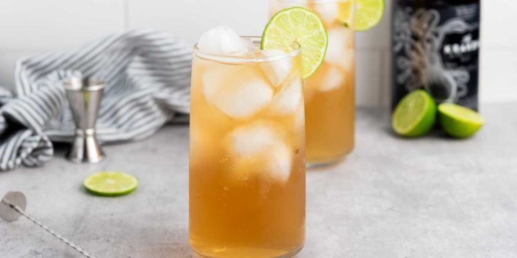 Dark and Stormy cocktail with dark rum, ginger beer, ice, and lime garnish in a tall glass.