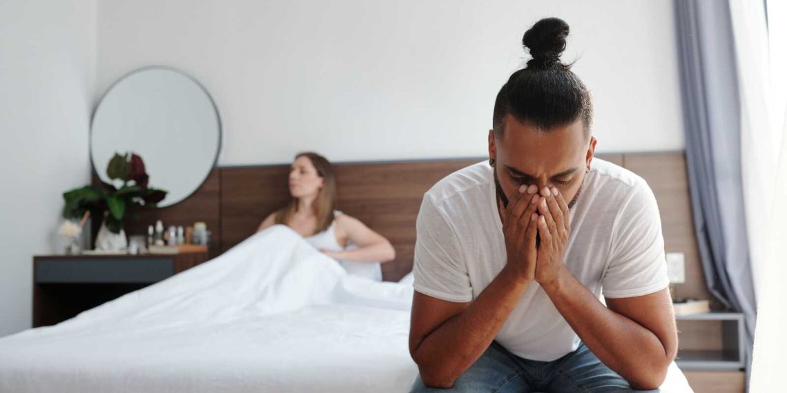 Couple experiencing emotional distance in bedroom, highlighting need for marriage counseling for sexless marriage
